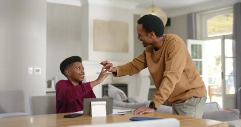 Father and son exchanging high five fist bump celebrating son raising hand at Stock Footage 337731549