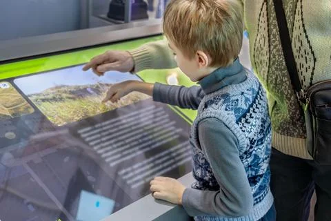 Father and Son Exploring Technology Together on Interactive Screen Stock Photos