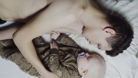 Father and son fall asleep in bed. Father puts the baby to sleep. 4k Top view Stock Footage 88869882