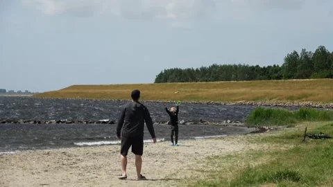 Father and son flying a kite in strong winds 動画素材 253703953