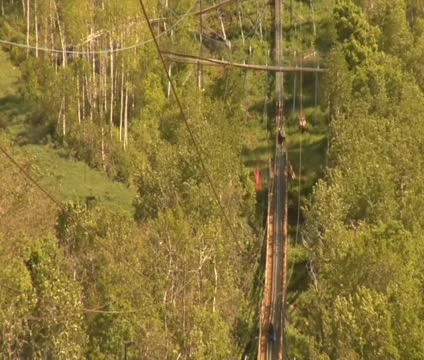 A father and son go down a mountain zipline Stock Footage 21671487