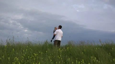 Father and son have fun together, spring meadow, rise up child, dramatic sky 4K Stock Footage 46206045