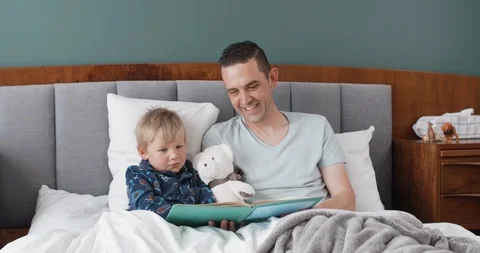 Father and son having fun reading books Stock Footage 120362041