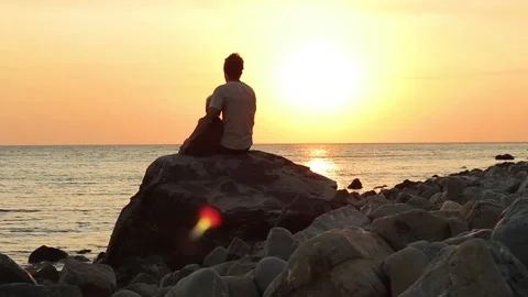 Father and son having fun at seaside silhouetted by setting sun sea background. 動画素材 129300061