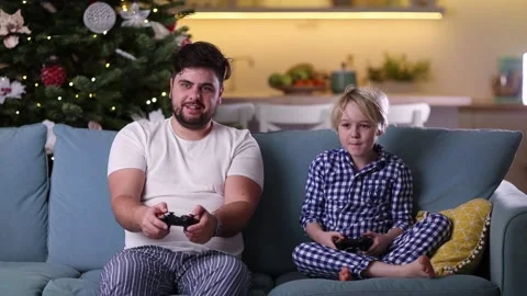 Father and son having fun together, playing video games at home in the evening Stock Footage 130443091
