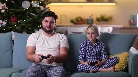 Father and son having fun together, playing video games at home in the evening Stock Footage 130443315