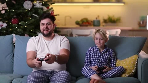 Father and son having fun together, playing video games at home in the evening Stock Footage 130443459