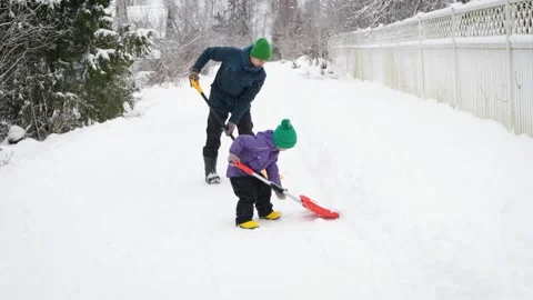 Father and son having fun on winter while shoveling fresh snow on rural road. Stock Footage 167373894