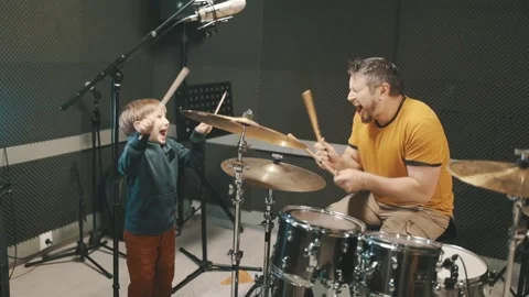 Father and son having fun playing drums in a music studio Stock Footage 328050850