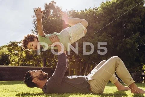 Father and son having fun playing in the park Stock Photos
