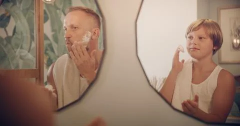Father and son having fun shaving. Quality time with kid. Mirror reflections Stock Photos
