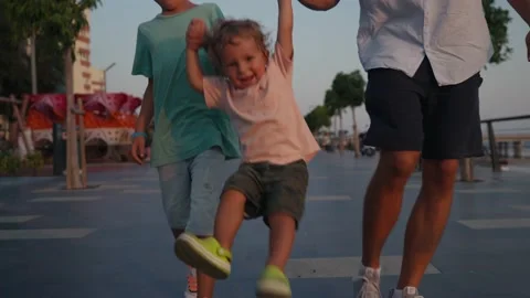Father and Son Holding Hands Walking Together with little brother on the Beach Vídeo Stock 207844577