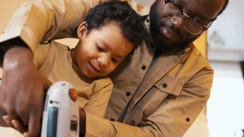 Father and son keeping screwdriver in hands together Stock Footage 100691026