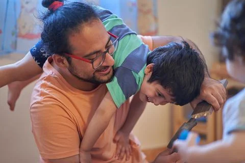 Father and son laugh while assembling wooden desk. Assembling furniture at ho Stock Photos