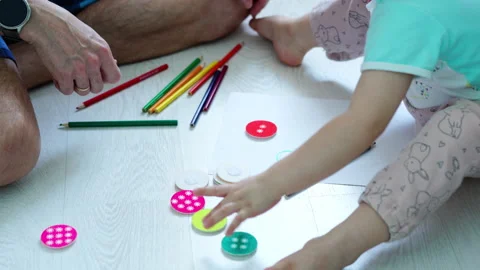 Father and son learning together on the floor, engaging with colorful shapes Video stock 329405538