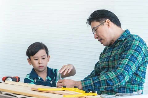 Father and Son is learning to work on wood work with tools for family togethe Stock Photos