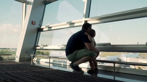 Father and son looking at airplanes through the glass window. Travel with baby Stock Footage 120067985