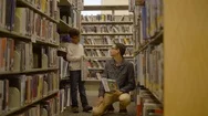 Father And Son Looking At Books Together At A Library Panning Shot Stock Footage