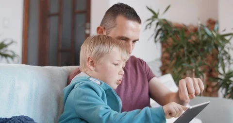 Father and son looking at tablet screen together Stock Footage 120345323