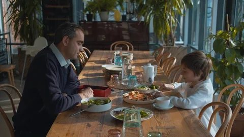 Father and son at lunch in a cafe, father cuts the pizza Stock Footage 120735586
