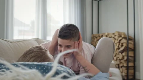 Father And Son Lying On The Couch In The Apartment. They Play And Joke. Young Stock Footage 146549404