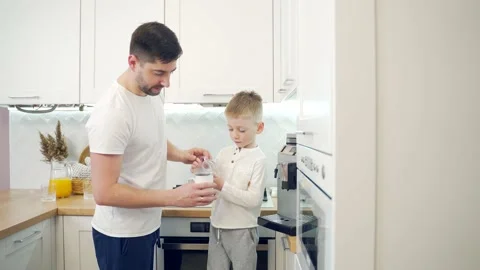 Father and son make coffee in the morning at home in the kitchen. dad together  Stock Footage 147303458