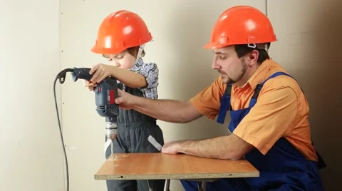 Father and son with one drill make hole Stock Footage 59130561