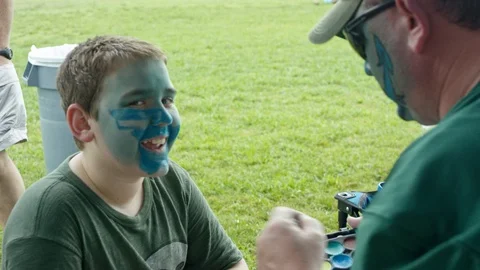 Father And Son Paint Faces For College Football Game Tailgate Video stock 108464669