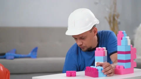 Father and son picking up bricks back on table while playing with his son in Stock Footage 132509900