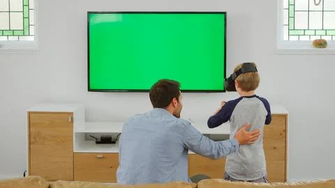 Father And Son Play Computer Game Using Virtual Reality Headset Stock Photos