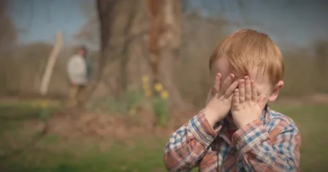Father and son play hide and seek around tree Stock Footage 60793904