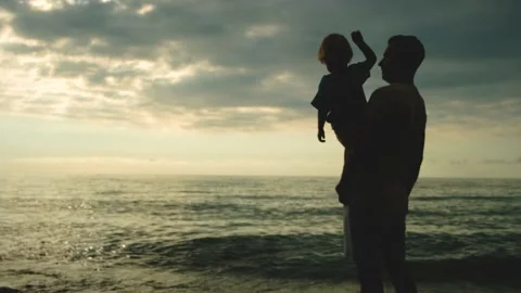 Father and son playing on the beach at the sunset time. Concept of friendly Stock Footage 200807501