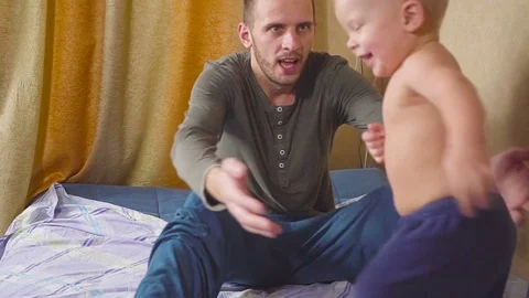 Father and son playing on bed hug and play Stock Footage 83382584