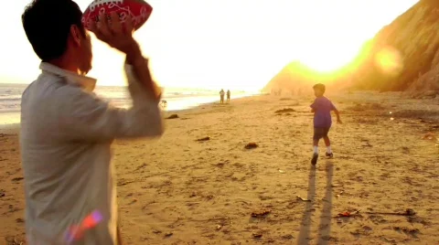 Father and Son Playing Catch on the Beach Stock Footage