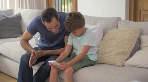Father and son playing with digital tablet Video stock 57828965