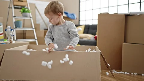 Father and son playing with foam cardboard box at new home Video stock 237293767