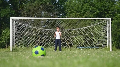 Father and son playing football on the football at the day time Stock Footage