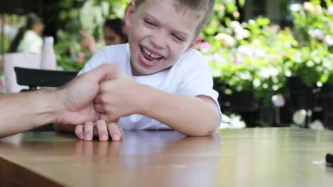 Father and son playing game at outdoor restaurant. Stock Footage 276950356