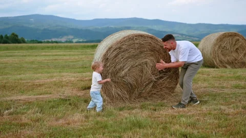 Father and Son Playing by Haystack with Mountain View on Family Holiday Stock Footage 307268787
