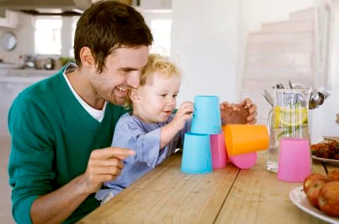 Father and son playing in kitchen Stock Photos