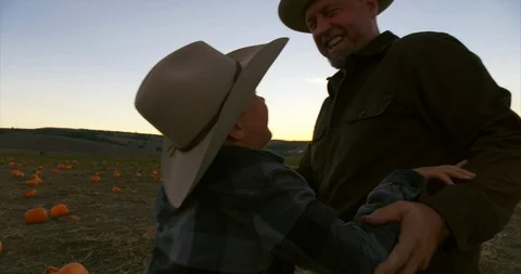 Father and son playing on a pumpkin field. Stock Footage 88373535