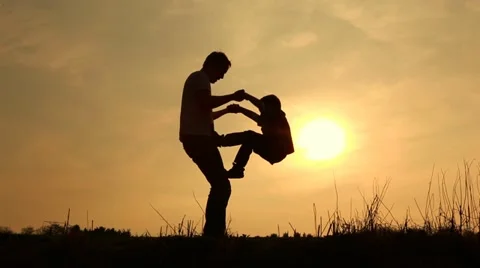 Father and son playing silouetted Stock Footage