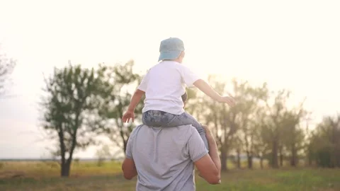 Father and son playing together piggyback in the park. Male care summer concept Video stock 319475772