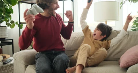 Father and son playing video game at home Stockbeeldmateriaal 145235083