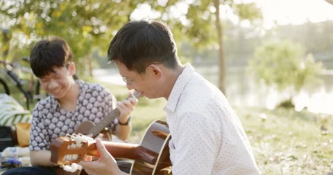 Father and son practice playing guitar with enthusiasm, happy relaxing  Video stock 166906193