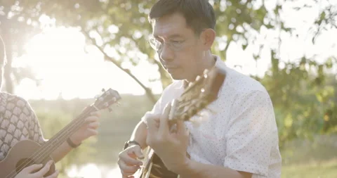Father and son practice playing guitar with enthusiasm, happy relaxing  Video stock 166906322