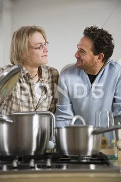 Father and son preparing meal in kitchen Stock Photos