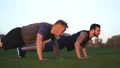 The father and a son pushing up on the grass 4k or 4k+ Resolution