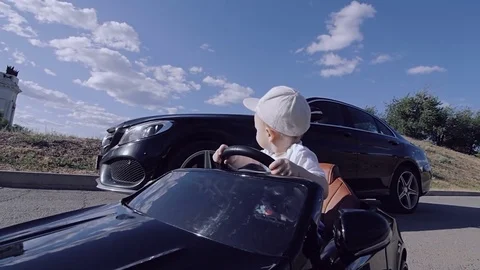 Father and son ride on two black cars. Everyone in his car. Stock Footage 77524965
