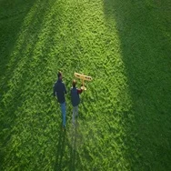 Father And Son Running In The Field With Model Airplane. Aerial Shot. Stock Footage